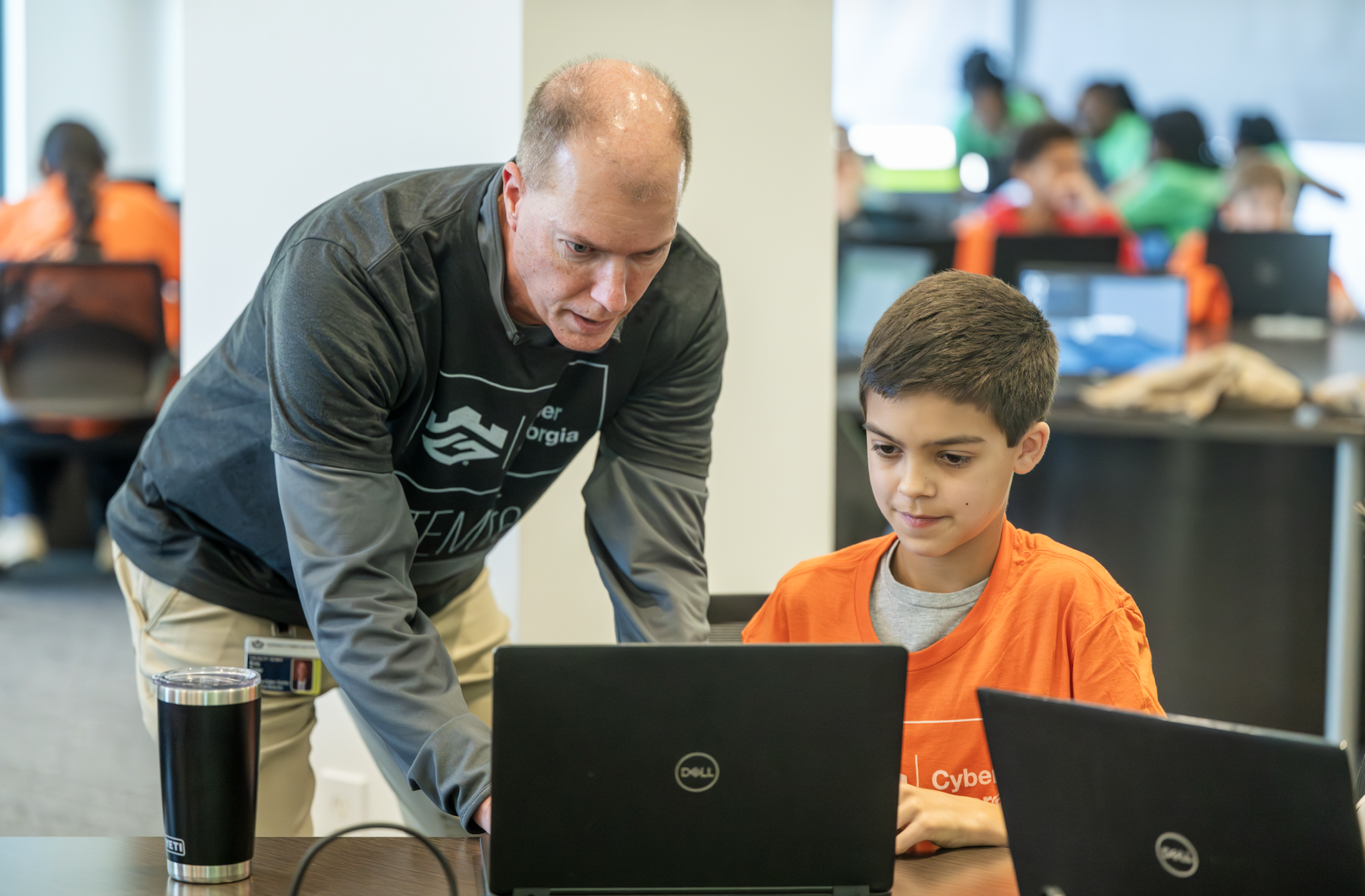 Executive Director Eric Toler assisting middle school student during 2026 Cyber Georgia STEMFest