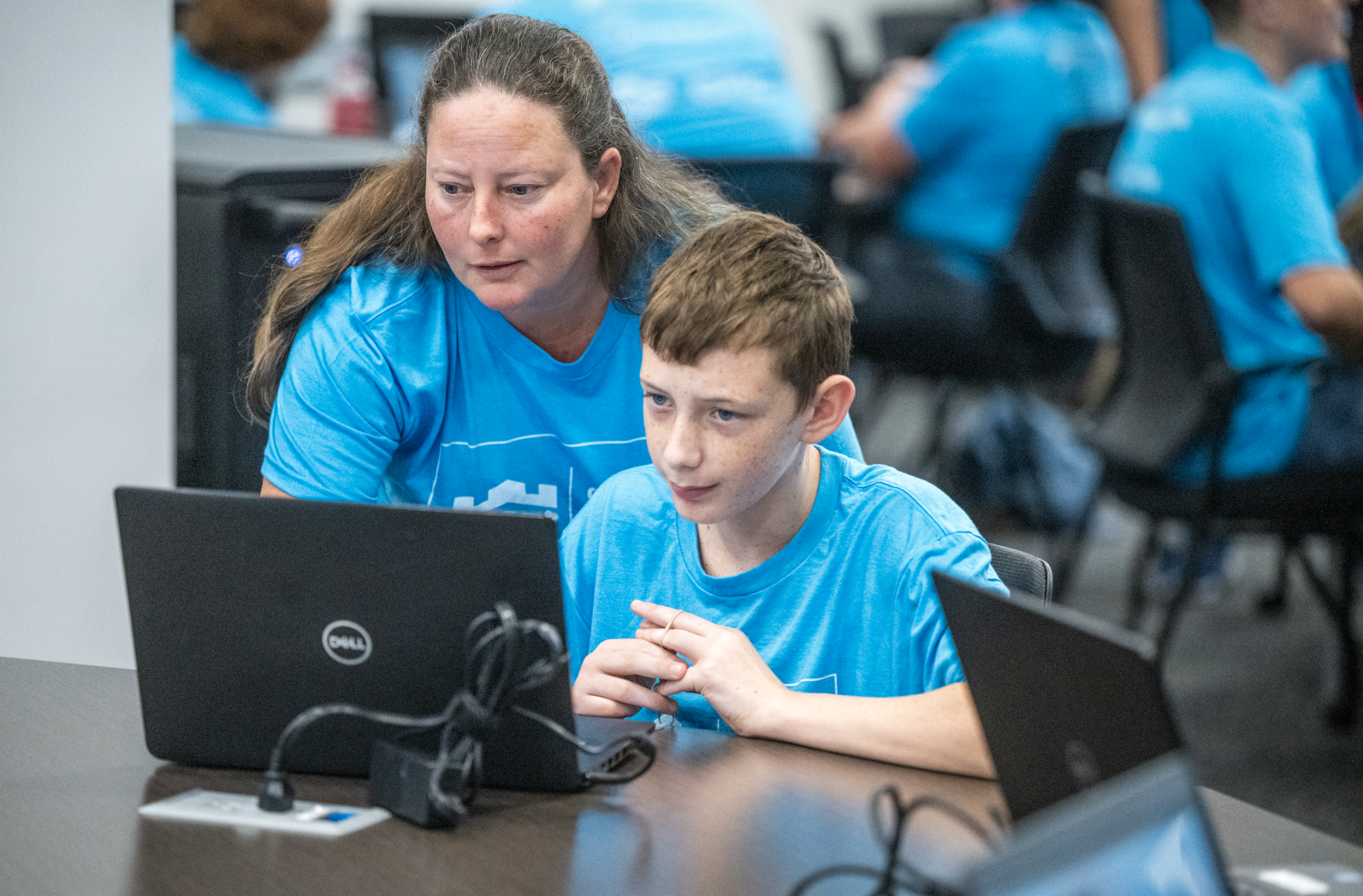 K-12 teacher helping student with cybersecurity activity 