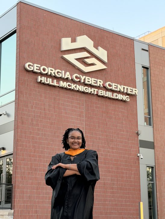 Graduate posing in front of Georgia Cyber Center