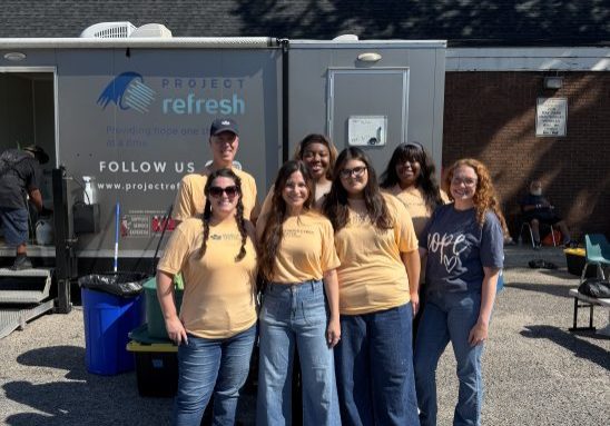 Georgia Cyber Center volunteers standing in front of Project Refresh mobile shower trailer at May Park